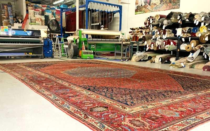 Infinity Rug Care workshop with Persian rug laid out for cleaning